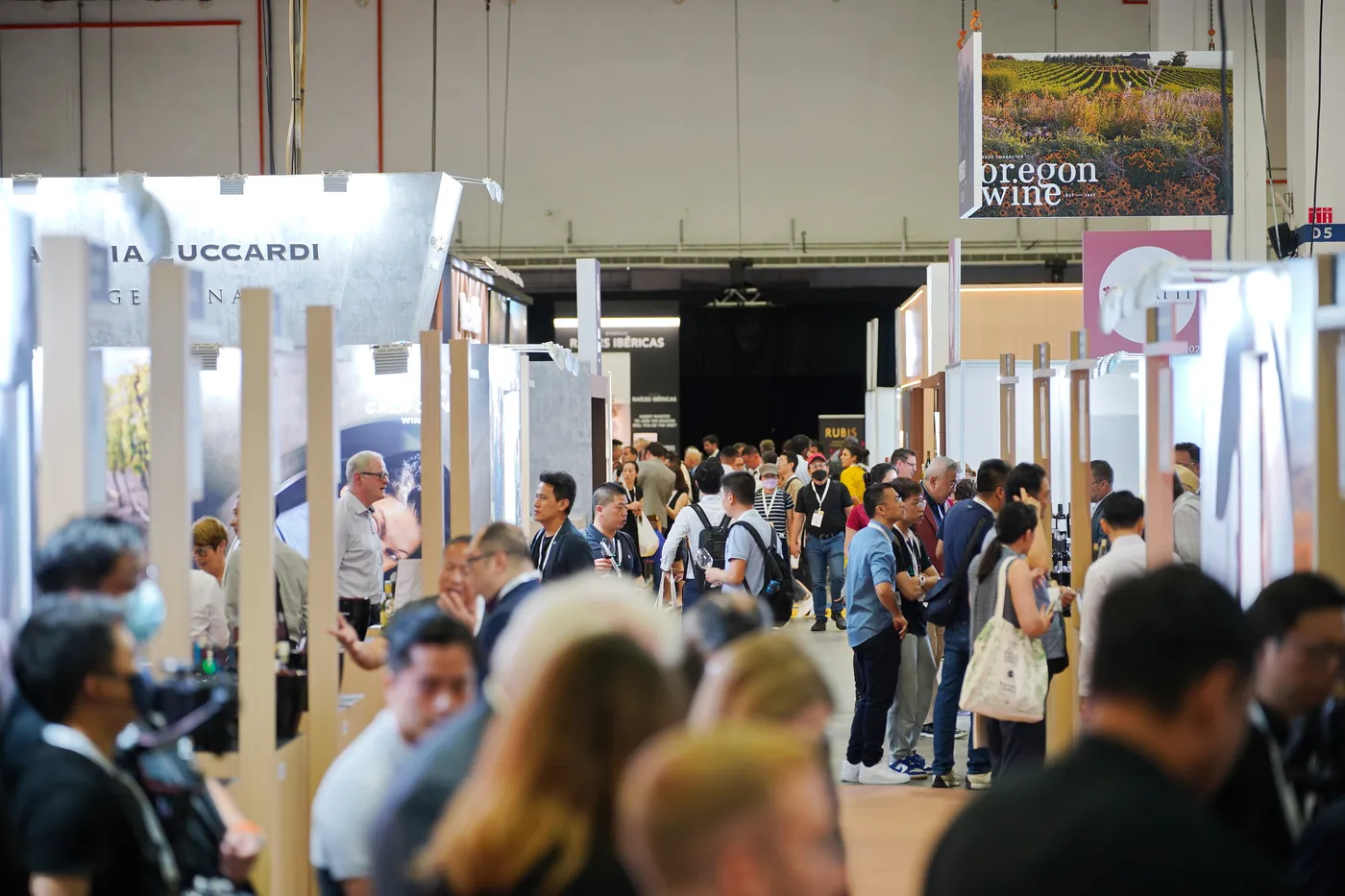 Allée de salon professionnel, visiteurs circulant entre les stands